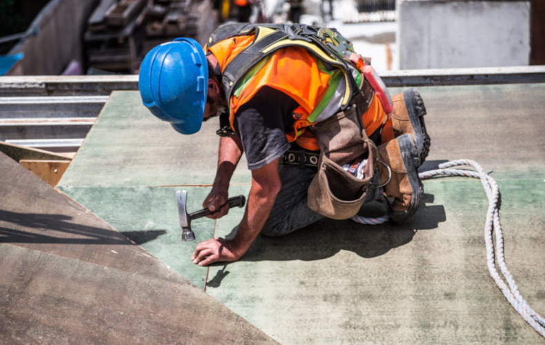 Artisan posant une cloison sur un chantier de construction