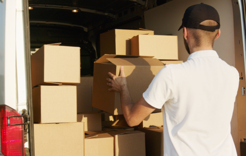 Déménageur rangeant des cartons dans son véhicule